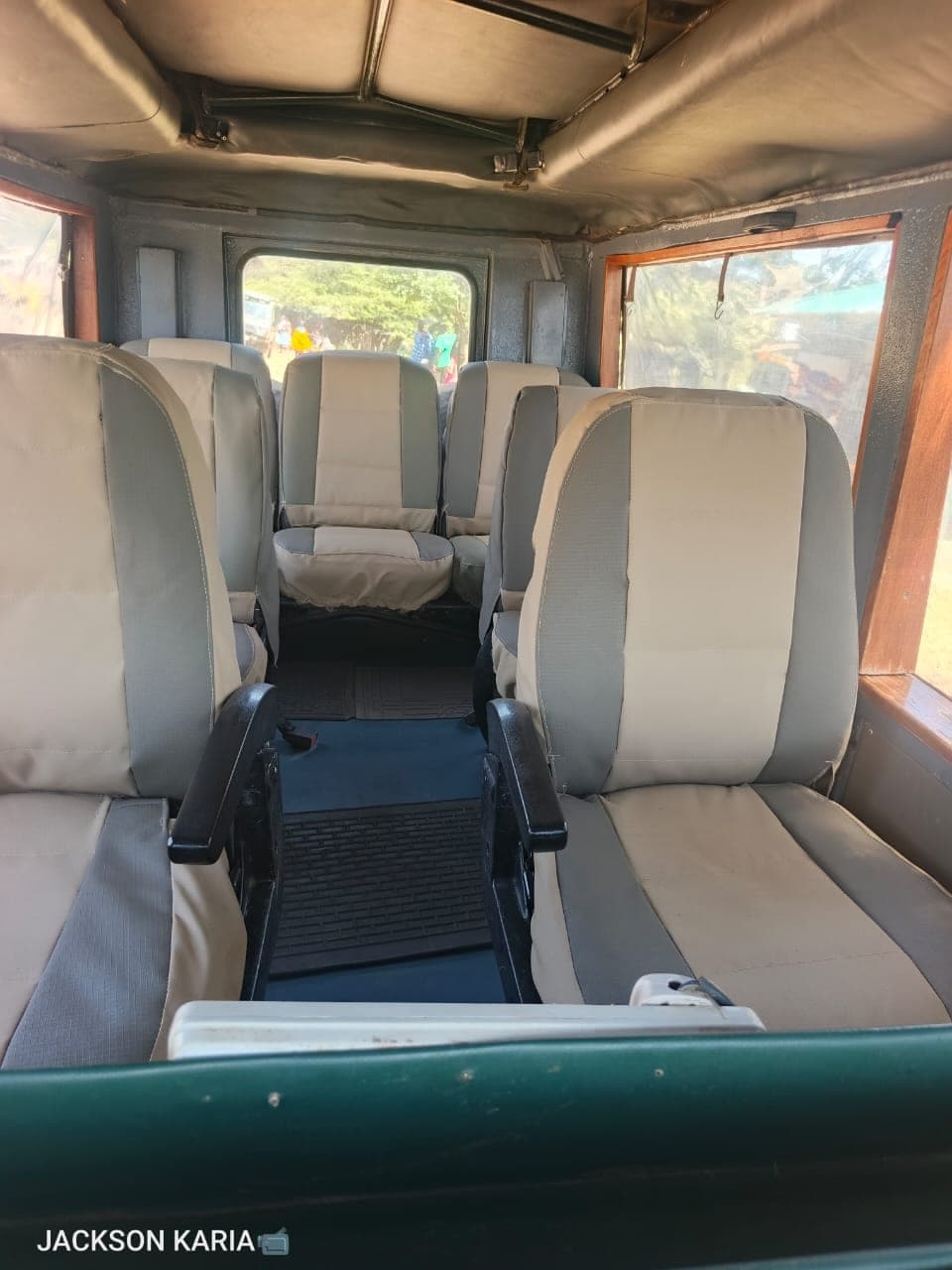 Interior of the open-roof safari Land Cruiser showing individual padded seats